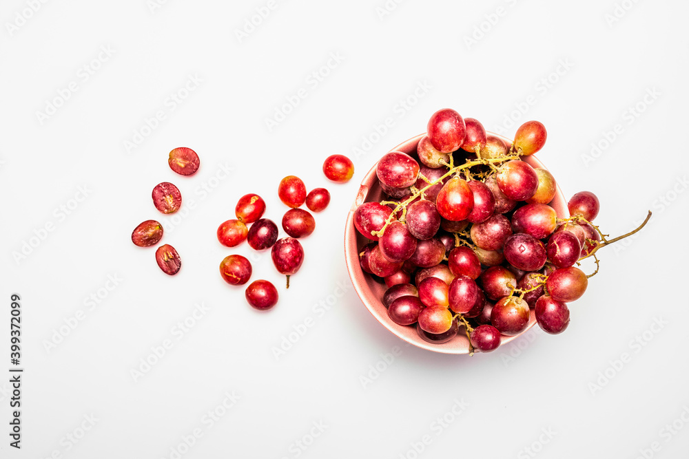 pink bowl with red grapes on white background pink bowl with red grapes on white background