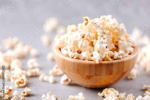 Homemade popcorn in a wooden bowl on a grey background
