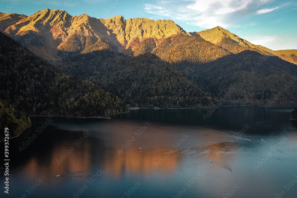 Beautiful mountain lake with reflection of mountains illuminated by the setting sun