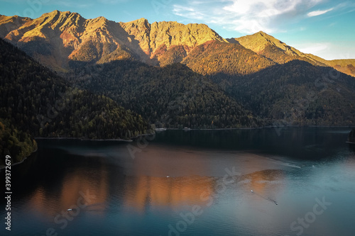 Beautiful mountain lake with reflection of mountains illuminated by the setting sun