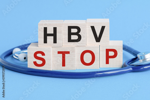 Wallpaper Mural Wooden block with words HBV Stop - with stethoscope on the table, insurance and medical concept, blue background Torontodigital.ca