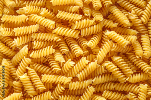 Dry pasta fusilli. Fusilli have spiral shape and yellow color. Pasta is delicious Italian traditional food made from wheat flour like noodles.Pasta background.Top view