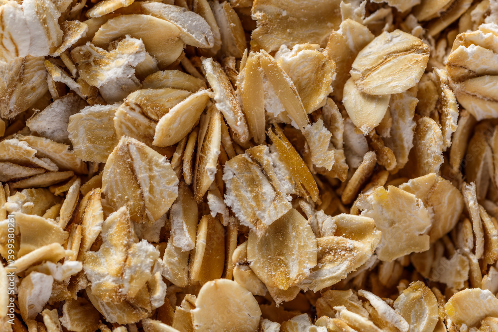 Background of oatmeal. Daylight. Throughout the frame are oatmeal flakes.Diet food concept.Top view Background of oatmeal. Daylight. Throughout the frame are oatmeal flakes.Diet food concept.Top view