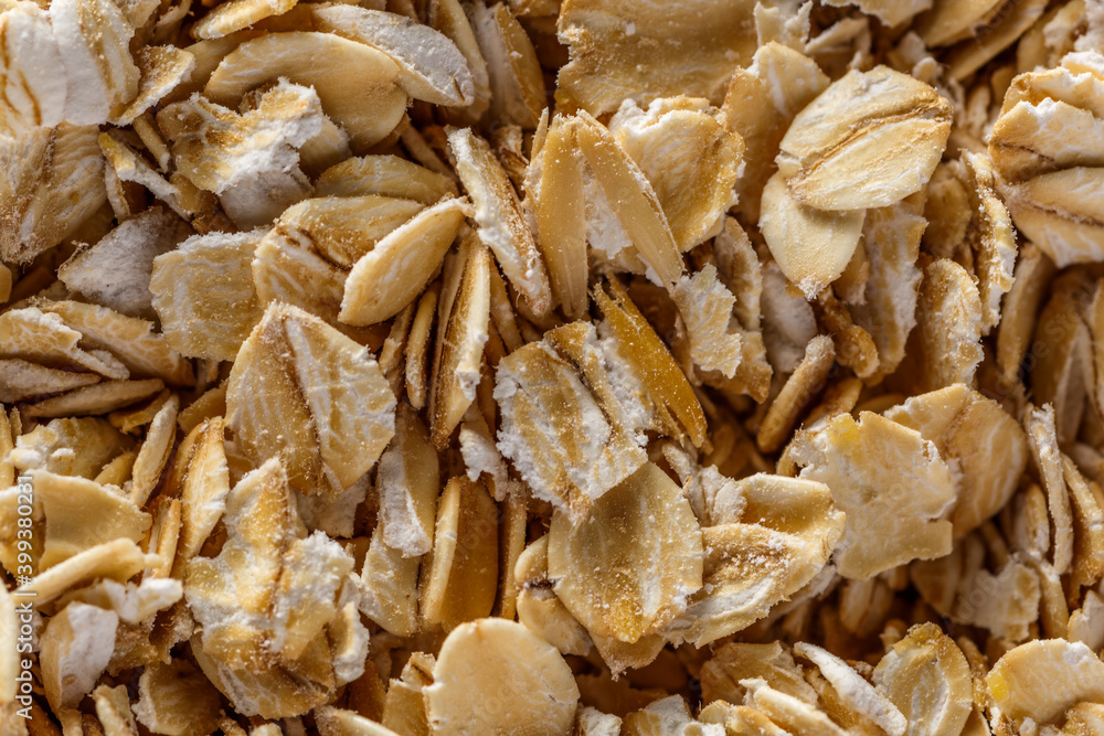 Background of oatmeal. Daylight. Throughout the frame are oatmeal flakes.Diet food concept.Top view