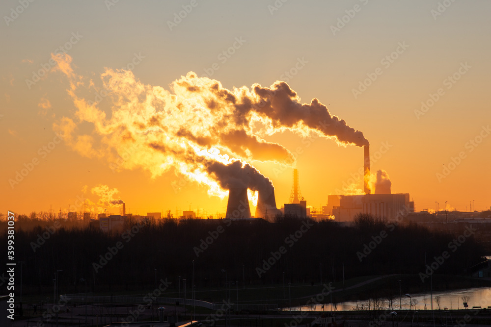 View of the beautiful sunrise over the pipes of the electric power station. Yuzhnaya Thermal Power Plant Saint Petersburg Russia. Smoke from chimneys.