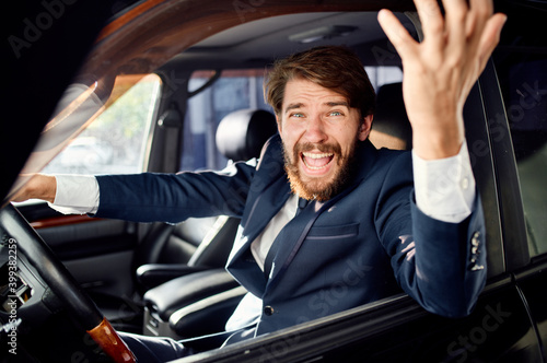 aggressive business man looking out of the car window and gesturing with his hands © SHOTPRIME STUDIO