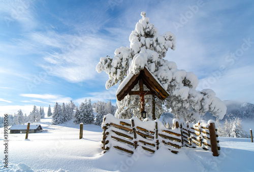 Holzkreuz im verschneiter Berglandschaft im Winter photo