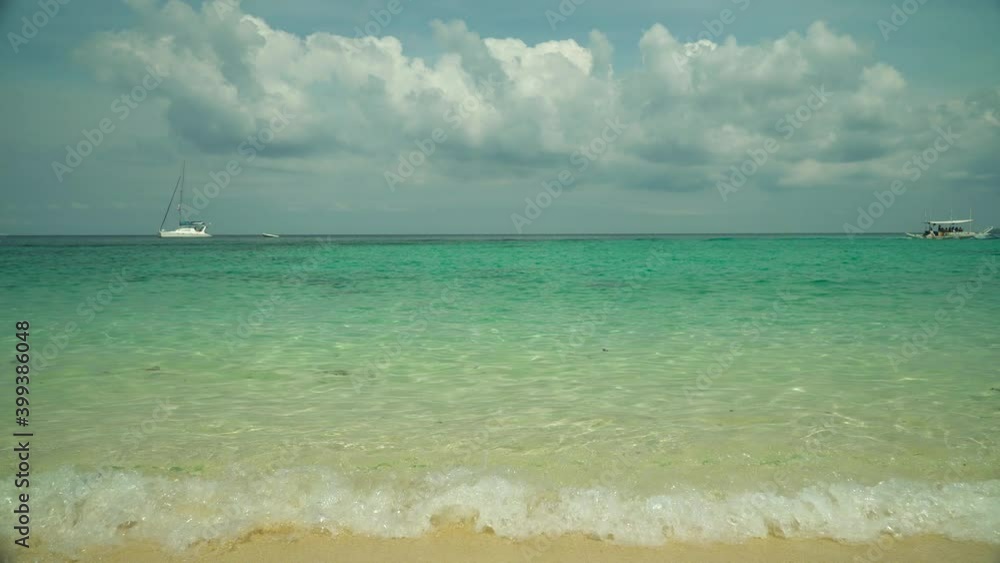 Tropical beach with boats and yachts on a background of sky and clouds. Summer and travel vacation concept. Tropical beach with boats and yachts on a background of sky and clouds. Summer and travel vacation concept.