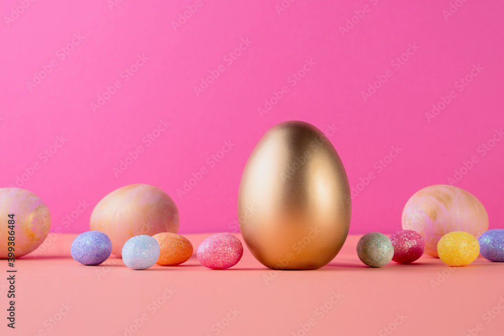 Trendy Easter background with Gold and colored Easter eggs on a light coral color background with copy space. Top view still life. Easter concept. Trendy Easter background with Gold and colored Easter eggs on a light coral color background with copy space. Top view still life. Easter concept.