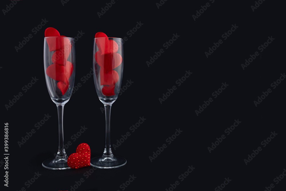 Two champagne glasses with red hearts for couple on black background. Happy valentines day dinner. 14 february. greeting card, banner. copy space, place for text Two champagne glasses with red hearts for couple on black background. Happy valentines day dinner. 14 february. greeting card, banner. copy space, place for text