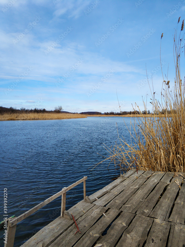 Obraz premium Quiet fishing spot by the river. View of the river from the bank
