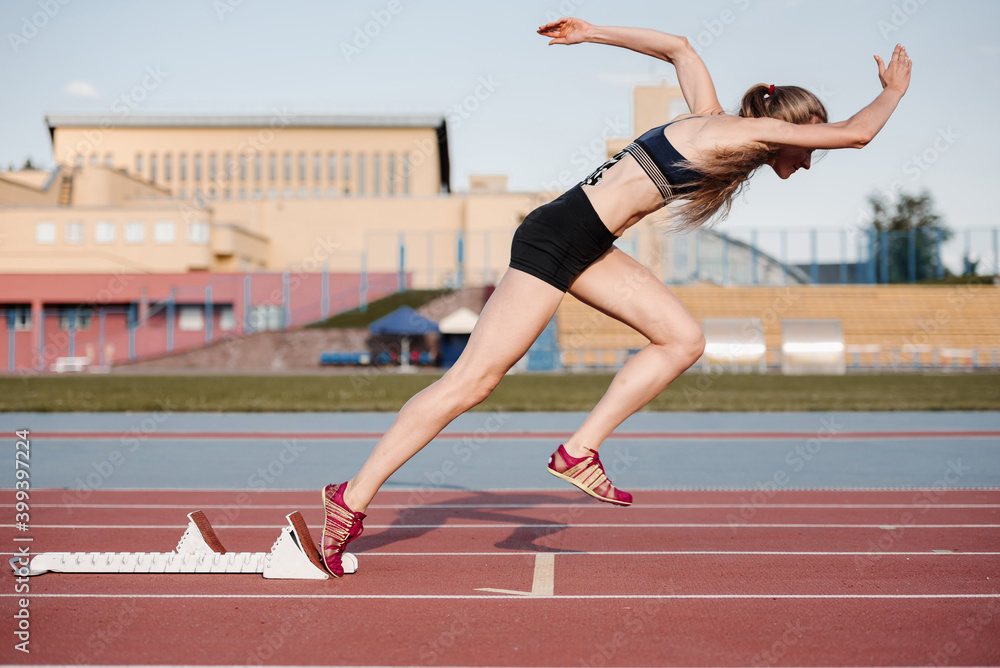 Sportswoman using starting block on start Sportswoman using starting block on start