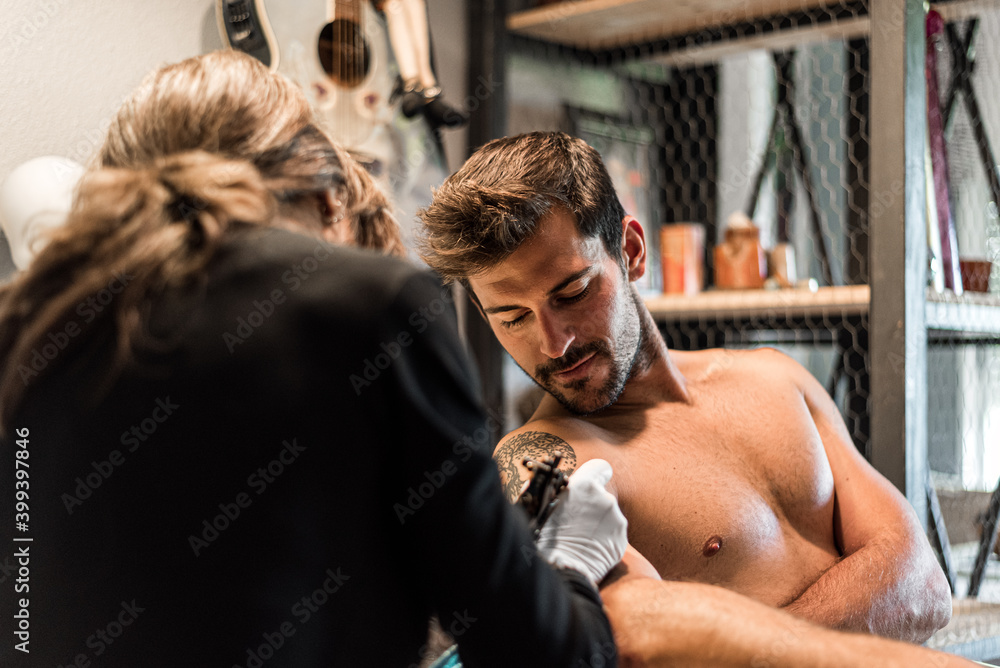 tattoo artist woman making tattoo to man tattoo artist woman making tattoo to man