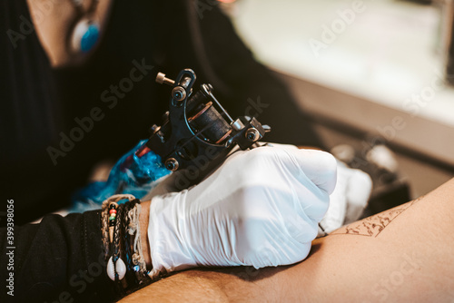tattoo artist woman making tattoo for man