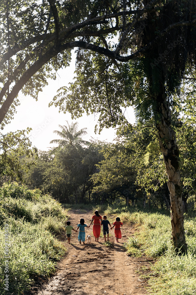 Backview of unrecognizable group of panamanian kids walking together holding hands Backview of unrecognizable group of panamanian kids walking together holding hands