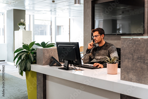 Busy employee calling on telephone at work space