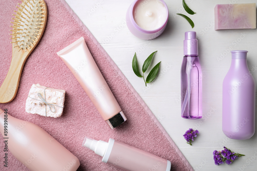 Flat lay composition with hair cosmetic products and towel on white wooden table Flat lay composition with hair cosmetic products and towel on white wooden table