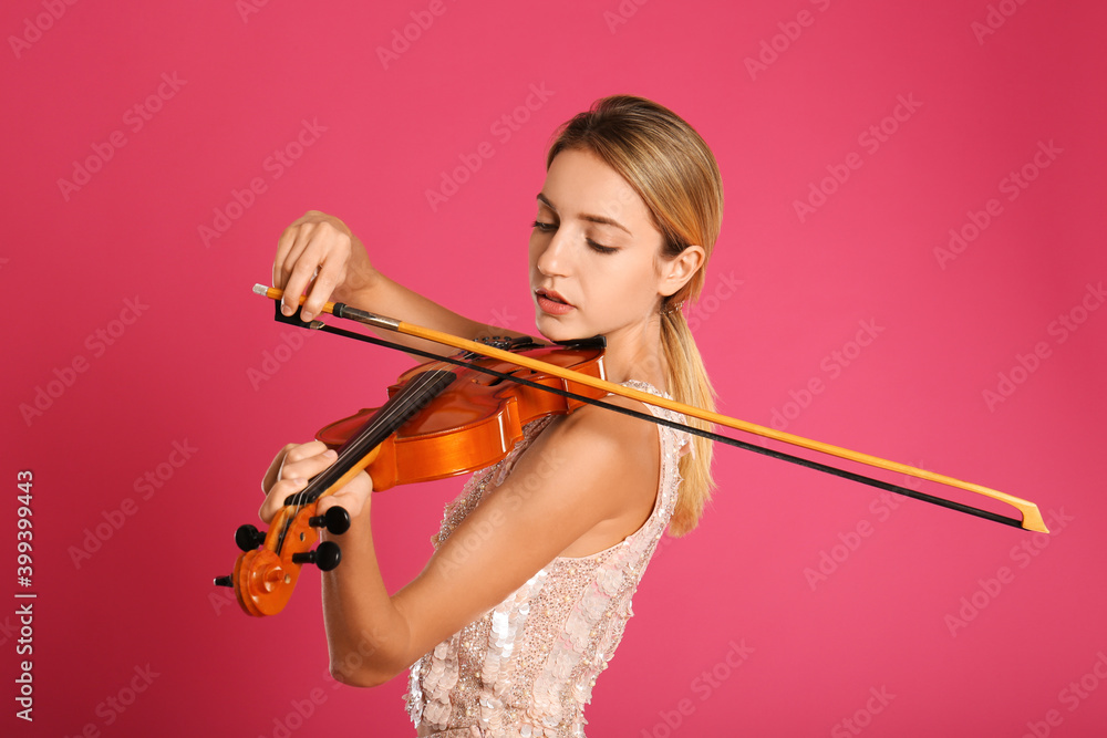 Beautiful woman playing violin on pink background Beautiful woman playing violin on pink background