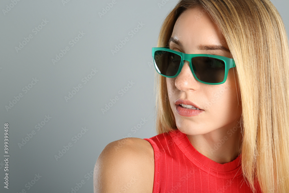 Beautiful woman in stylish sunglasses on grey background, closeup. Space for text Beautiful woman in stylish sunglasses on grey background, closeup. Space for text