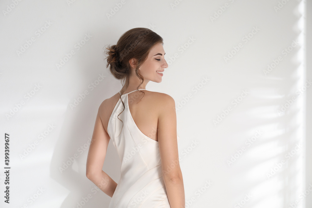 Young bride wearing beautiful wedding dress on light background Young bride wearing beautiful wedding dress on light background