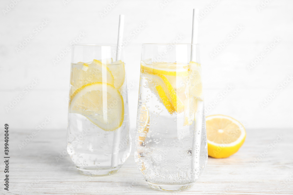 Soda water with lemon slices and fresh fruit on white wooden table Soda water with lemon slices and fresh fruit on white wooden table