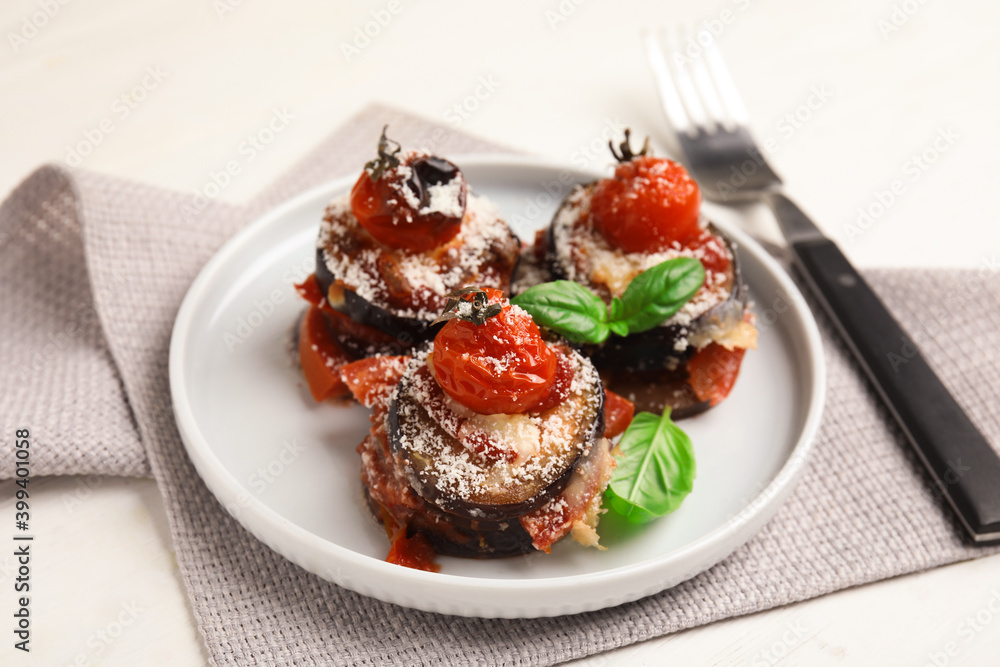 Baked eggplant with tomatoes, cheese and basil served on white wooden table Baked eggplant with tomatoes, cheese and basil served on white wooden table