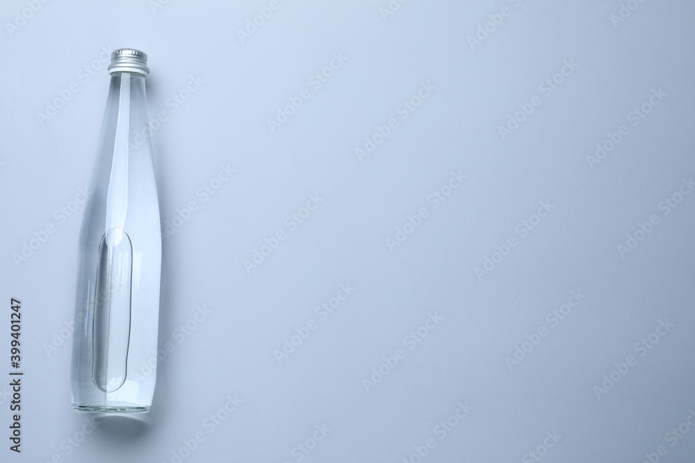 Glass bottle with water on white background, top view. Space for text Glass bottle with water on white background, top view. Space for text