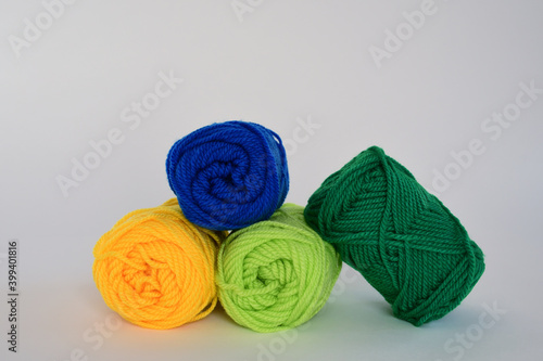 Colorful wool yarn balls on white background.