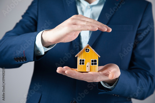 man holding wooden house model