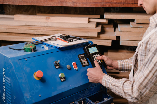 Crop carpenter pushing buttons on control panel photo