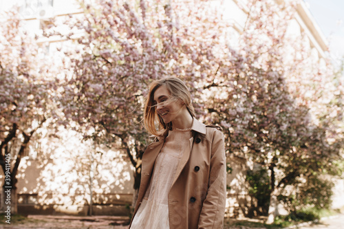 Smiling young woman by blossoming trees photo