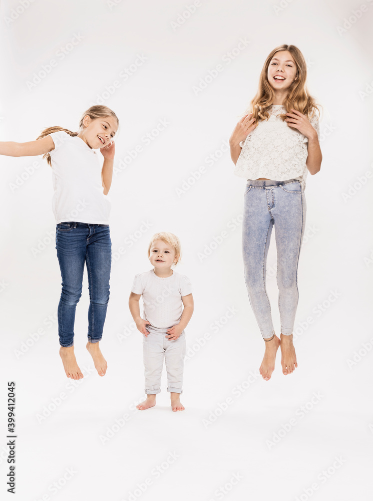 Sisters jumping against white background in studio Sisters jumping against white background in studio