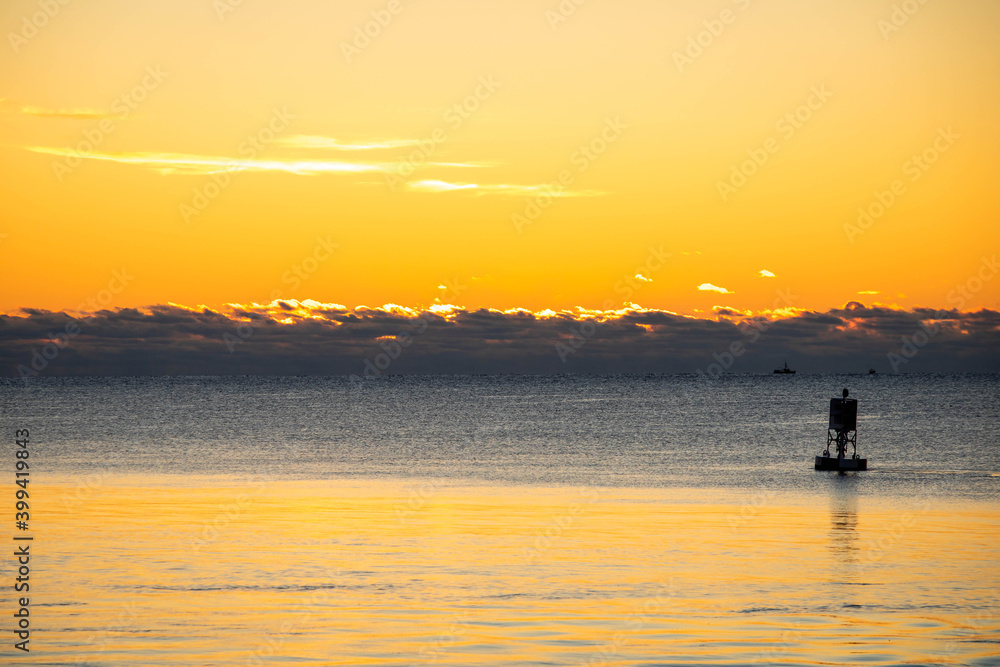 Scenic view of the ocean at sunrise vivid colors with buoy