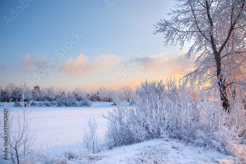 Evening on the river. Beautiful winter landscape with frost. Sunset, fog, haze