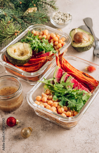 Vegan healthy meal prep containers. Chickpeas, sweet potatoes, arugula, radish and avocado for lunch
