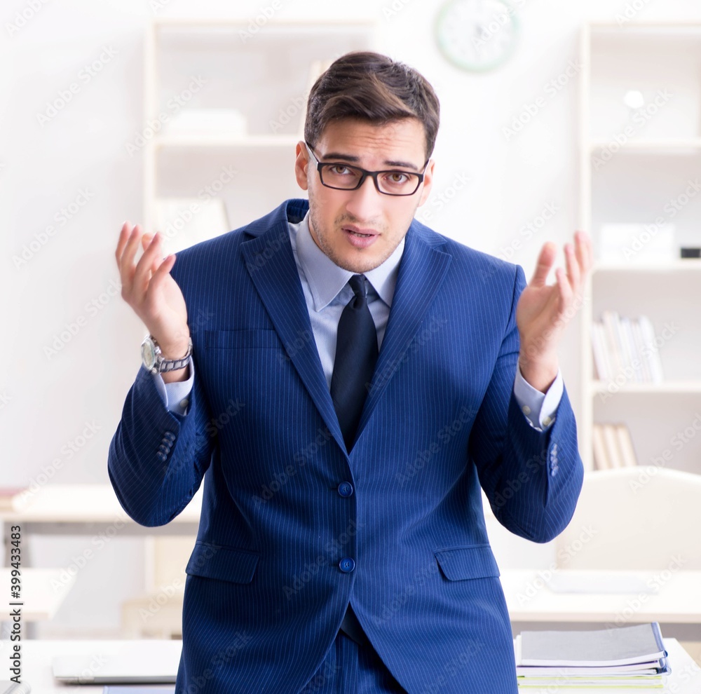Young handsome businessman employee working in office at desk Young handsome businessman employee working in office at desk