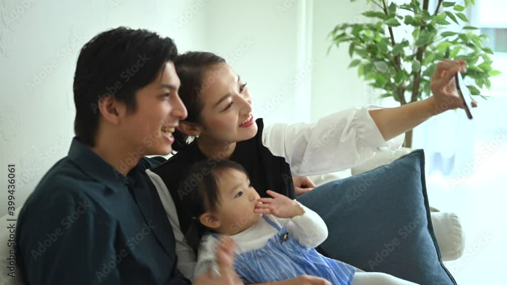 スマートフォンで自撮りをする赤ちゃんと夫婦