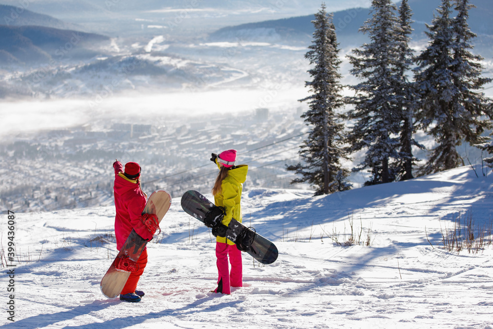 Two Woman snowboarders on the snowy mountain. Two Woman snowboarders on the snowy mountain.