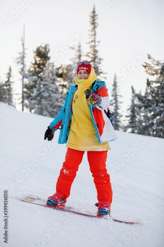 Woman is snowboarding on the snowy slopes.