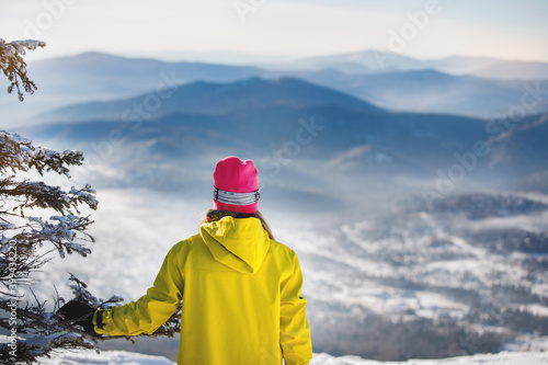 Woman skier looks into the distance, at the blue mountains.