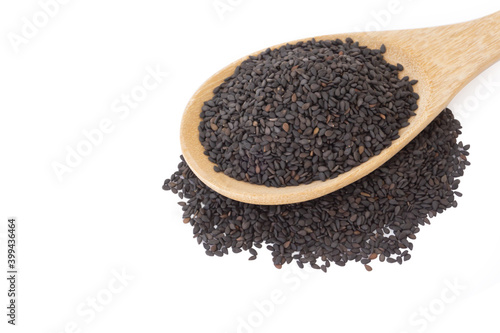 Closeup black sesame seeds on wood spoon with white background, healthy food concept