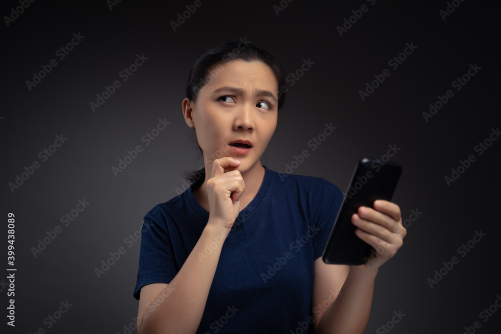 Asian woman looking at smart phone and feel confused. Asian woman looking at smart phone and feel confused.