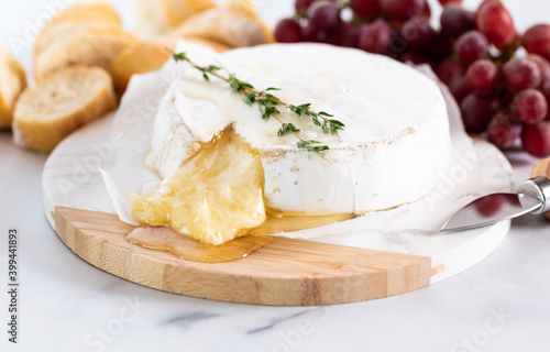 Baked brie served with grapes and crusty bread rounds.