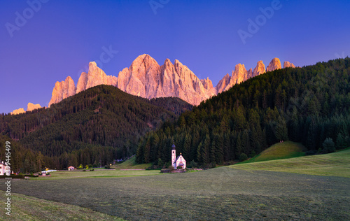 Dolomites at dusk with St Johann Church. Italy photo