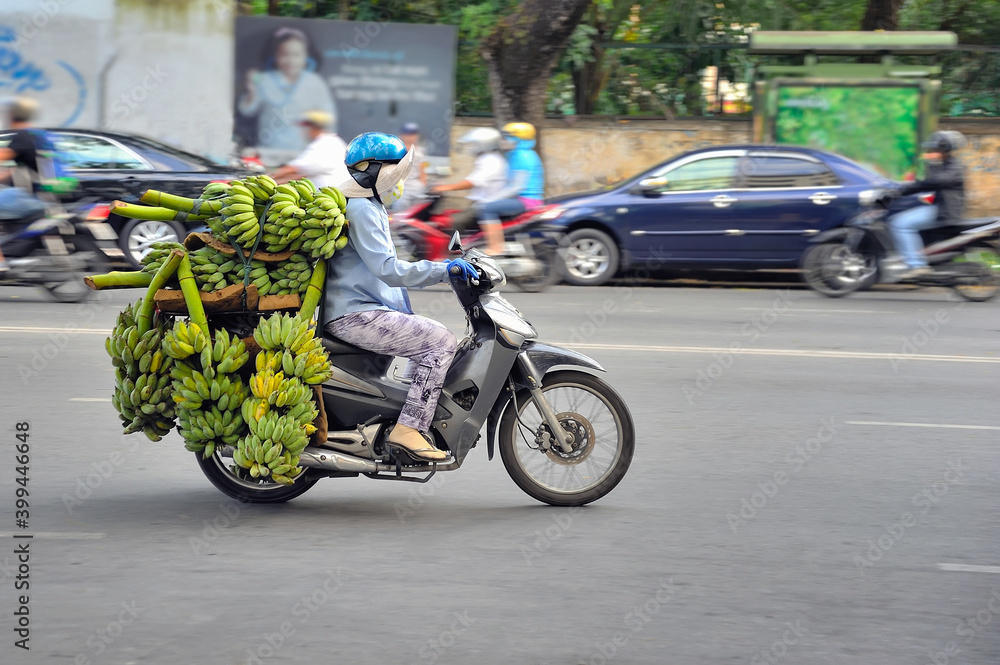 Woman carrying banana on a motorbike in the street of Ho Chi Minh city, Vietnam.