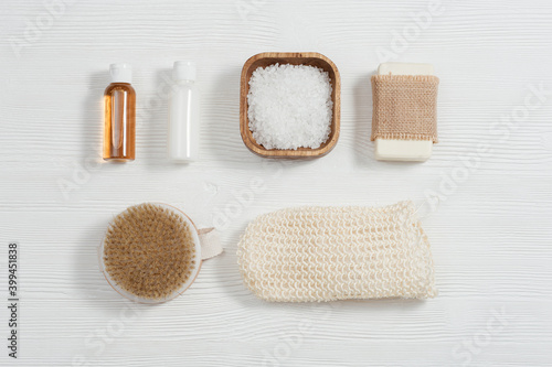 Spa setting for body care and beauty treatment. Bottles with gel and shampoo, soap, sea salt, washcloth for bath.
