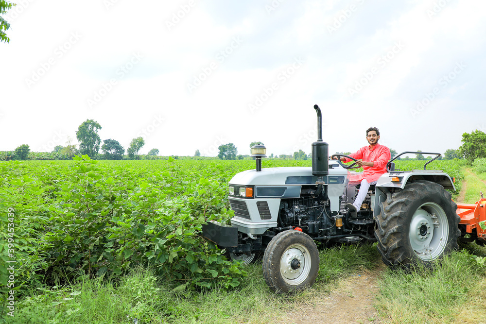 Indian farmer working with tractor at field Indian farmer working with tractor at field
