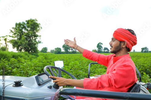 Indian farmer working with tractor at field