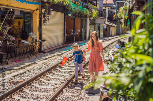 Mother and son travelers walk around railway paths which go through residential area in Hanoi city. Hanoi Train Street is a famous tourist destination. Vietnam reopens after coronavirus quarantine