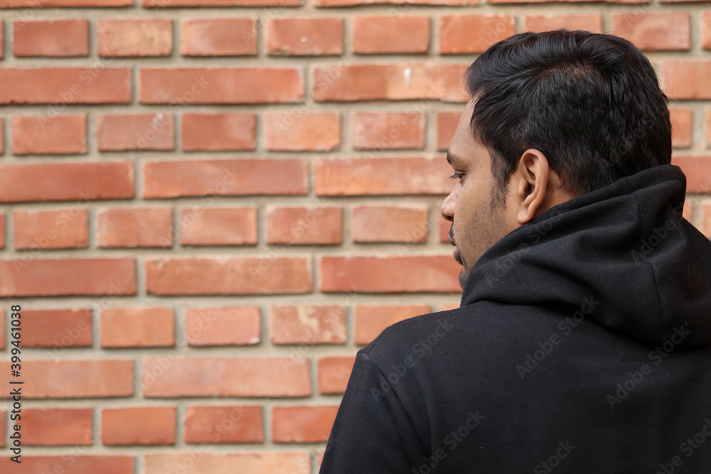 casual Young man Standing back showing half face and thinking in the Outdoor casual Young man Standing back showing half face and thinking in the Outdoor